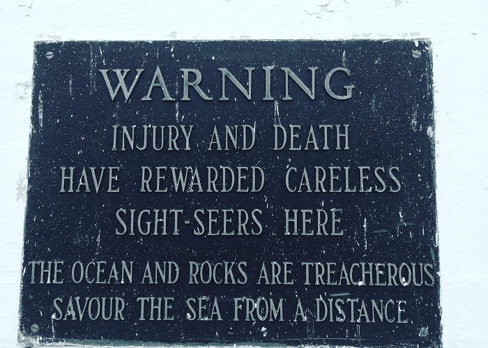 Peggys Cove Lighthouse Warning sign near Peggy's Cove lighthouse. Nova Scotia, Canada ... photo